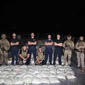Lancaster's sailors and Royal Marines pose with the haul of hashish:HMS Lancaster sailors and Royal Marines pictured alongside the haul of hashish. Picture: Royal Navy