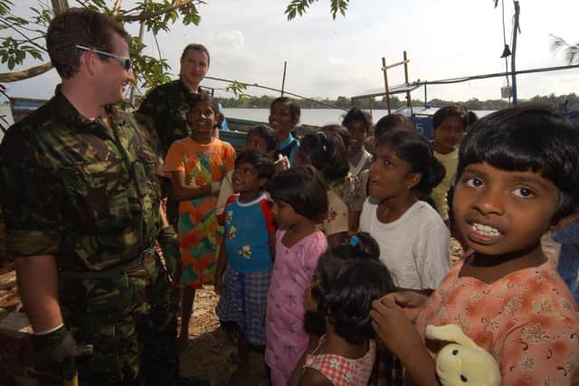 Royal Navy personnel from The Forward Support Unit, Portsmouth provide aid to locals in Batticoloa, one of the worst hit areas in the town.