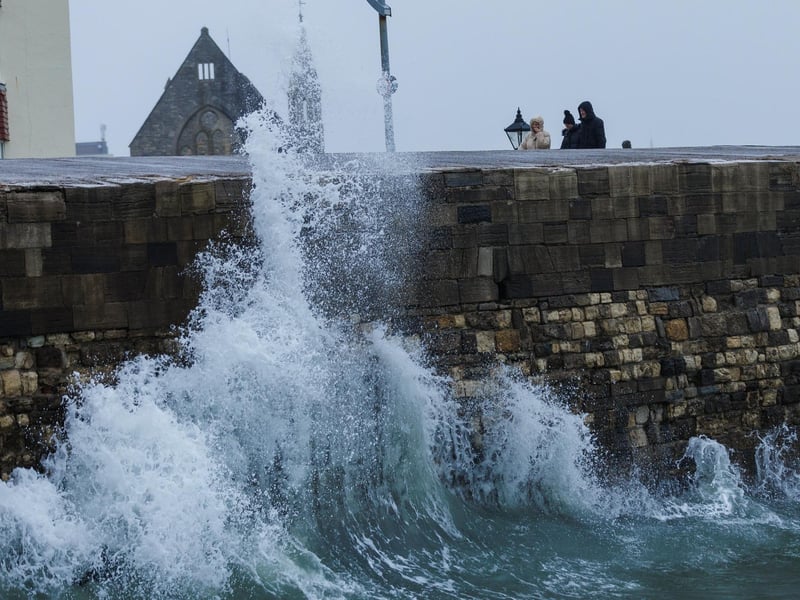 A moody sea crashed waves high onto footpaths as passer-by's did their best to get out the way