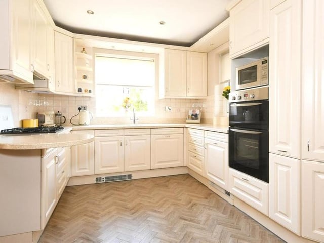 From the dining room, we move into the modern kitchen. It boasts a range of units and space for all the appliances you need.