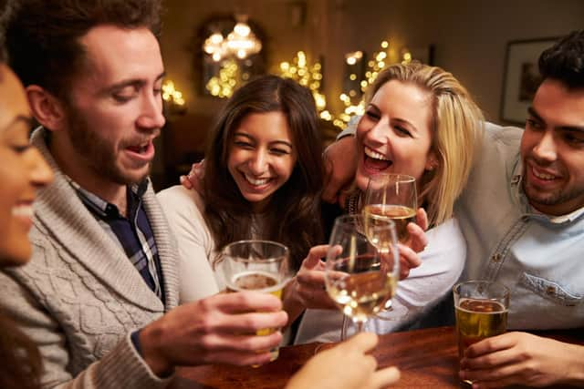 A group of friends enjoying an evening at the pub. Pictured posed before the coronavirus pandemic by models. Photo: Shutterstock