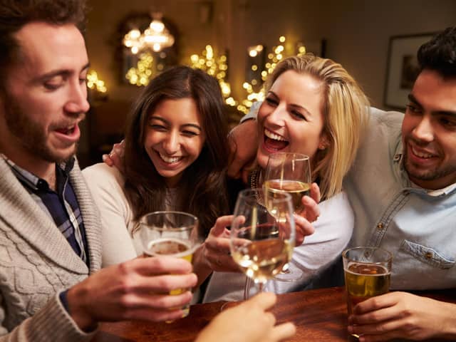 A group of friends enjoying an evening at the pub. Pictured posed before the coronavirus pandemic by models. Photo: Shutterstock