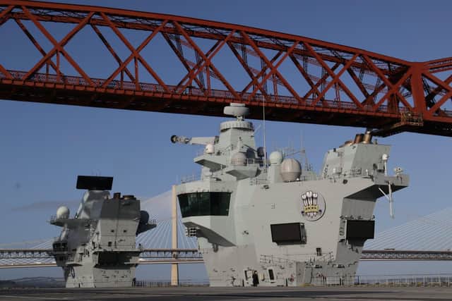 HMS Prince of Wales as she sails underneath the iconic Forth Bridge.