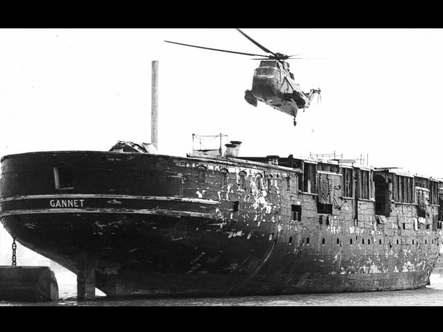 HMS Gannet before restoration moored up Fareham Creek. The helicopter is a brand new Sea King which simulated a landing before flying off to Prestwick in Scotland.