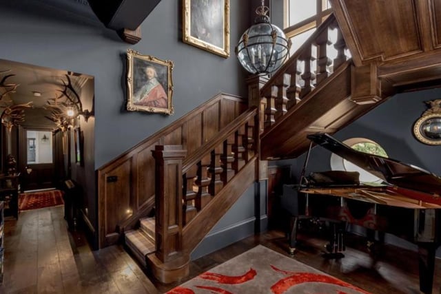 The hallway features a wooden staircase up to the first floor and a Jacobean mullioned window above, boasting a rich wooden design.