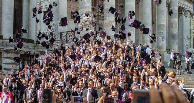 Graduates throw their mortar boards in the air during a University of Portsmouth graduation ceremony at The Guildhall, Portsmouth. Photo: Melanie Leininger.