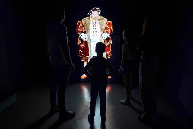 A family watches a video performance by a Henry VIII interpreter during a preview of the new 1545 experience at The Mary Rose exhibition at Portsmouth Historic Dockyard. Picture: Andrew Matthews/PA Wire