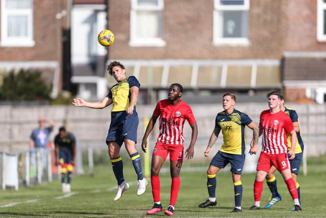 Rising high - Joe Briggs, left, wins this aerial ball against Camberley. Picture: Chris Moorhouse