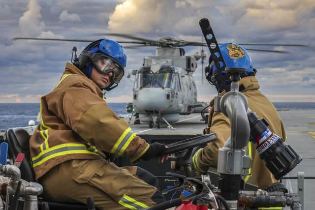 Royal Navy fire fighters on stand by with multiple aircraft on the deck. Picture: LPhot Finn Stainer- Hutchins.
