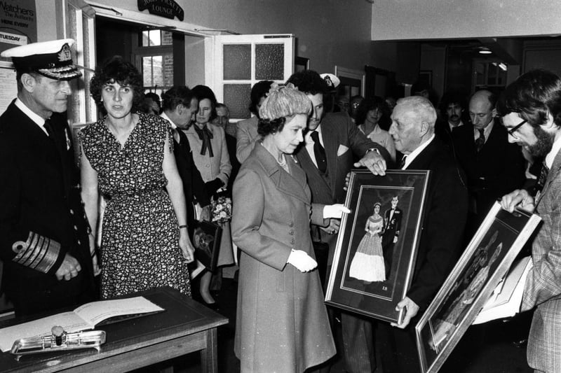 The Queen and Prince Philip are presented with paintings during their visit to Portsmouth in 1980. The News PP5127