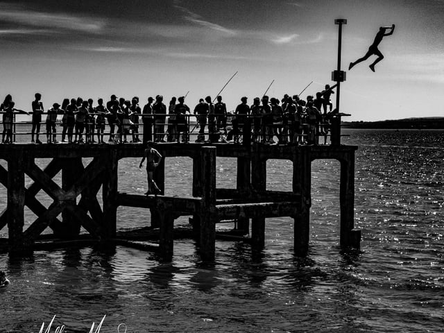 Summer silhouettes at the pier. We don't condone tombstoning, even though this is a great shot that captures the moment, tombstoning is particularly dangerous as water depth can be unpredictable as it changes with the tide.