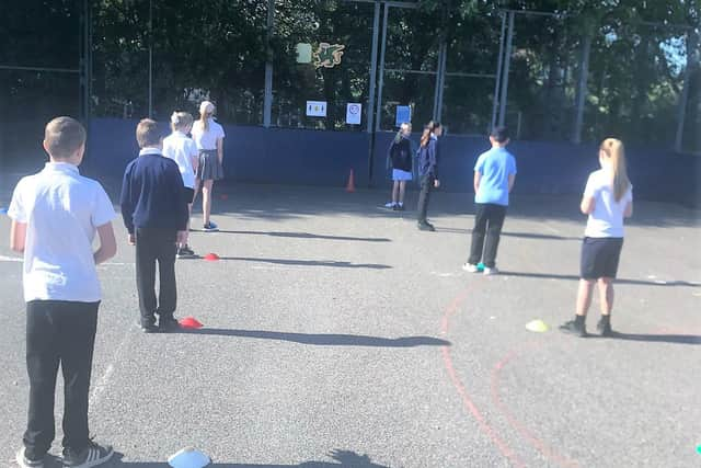 Year 6 pupils at St George's Beneficiary C of E Primary School line up two metres apart.