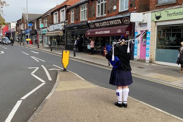 The funeral cortege of Doreen Colwell, 85, passes through High Street, Cosham, as musician Caroline Henton, 57, plays the bagpipes