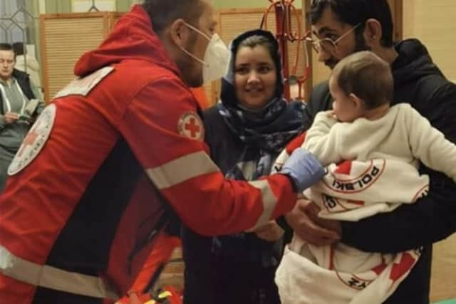 A Red Cross medic in Poland helps a newly arrived family from Ukraine.