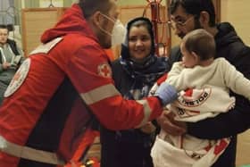 A Red Cross medic in Poland helps a newly arrived family from Ukraine.