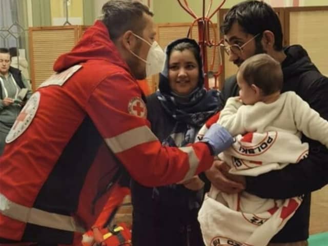 A Red Cross medic in Poland helps a newly arrived family from Ukraine.