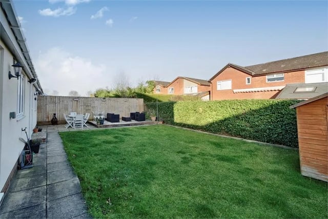 Generous laid to lawn garden with a paved pathway and pathways, enclosed with wood fencing and hedgerows.