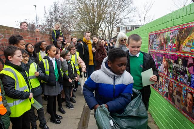 Teddy and Tacey, both nine, unveil the second piece of artwork as other pupils watch. Picture: Habibur Rahman