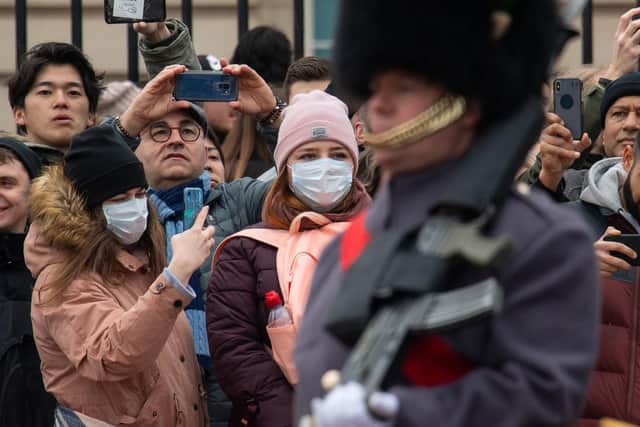 People wearing protective face masks watch the Changing of the Guard ceremony outside Buckingham Palace Picture: Dominic Lipinski/PA Wire