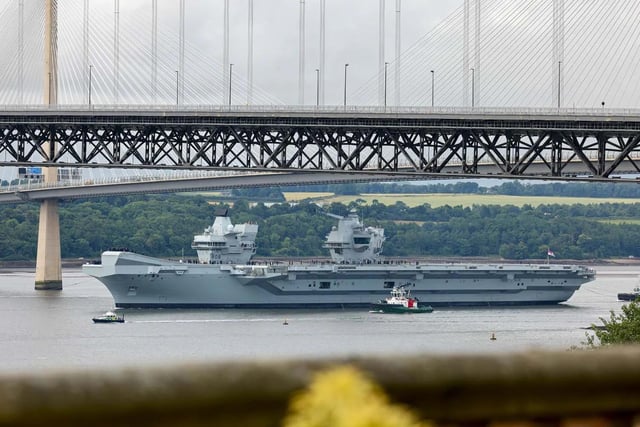 HMS Queen Elizabeth leaving Rosyth in Fife, Scotland, and sailing under the Forth bridge. She is due to return home to Portsmouth on July 30.