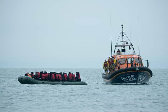 Migrants are helped by RNLI (Royal National Lifeboat Institution) lifeboat before being taken to a beach in Dungeness, on the south-east coast of England, on November 24, 2021, after crossing the English Channel. Picture: Ben Stansall/ AFP via Getty Images.