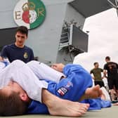 Sailors work on their ground-based skills as one is placed in an arm bar submission hold on HMS Queen Elizabeth. Photo: Royal Navy/Twitter