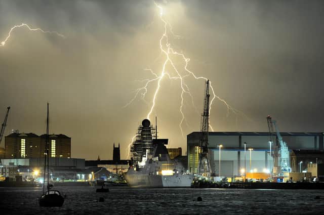 18th July 2014. A lightning thunderstorm passes over Portsmouth in the early hours of Friday Morning. Viewed from Gosport. Pictured is HMS Dauntless docked at the Portsmouth Naval base with the BAE shipyard right.
Picture: Paul Jacobs (142100-30)