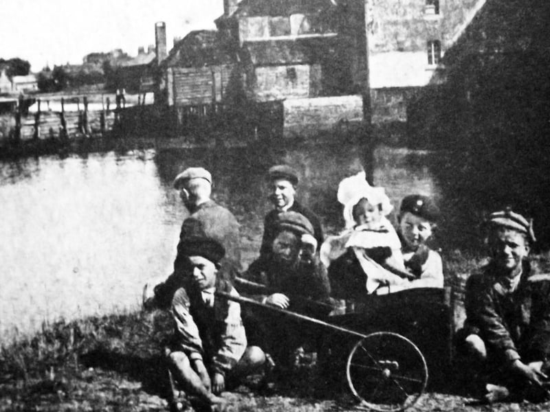 Beside Slipper Mill, Emsworth. With a baby wrapped up against the chill Emsworth boys gather alongside Slipper Mill. Picture: Tony New.