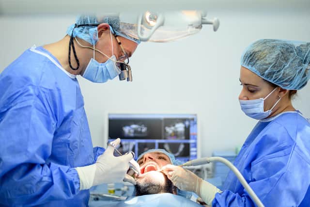 Dental surgeon and assistant work putting dental implant. Picture: Adobe Stock
