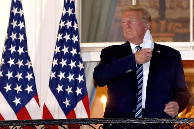 US President Donald Trump removes his mask upon return to the White House from Walter Reed National Military Medical Center on October 05, 2020 in Washington, DC. Trump spent three days hospitalized for coronavirus. Photo by Win McNamee/Getty Images.