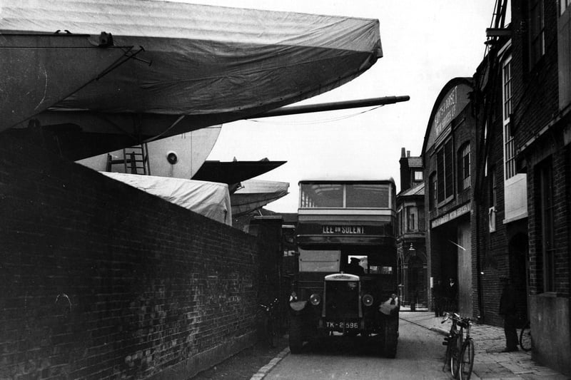 13th December 1936:  Owing to the length of the yacht 'Yankee', this Lee on Solent bound bus has to pass beneath its overhanging bow to get to and from its garage in Gosport, Hampshire.  (Photo by Fox Photos/Getty Images)
