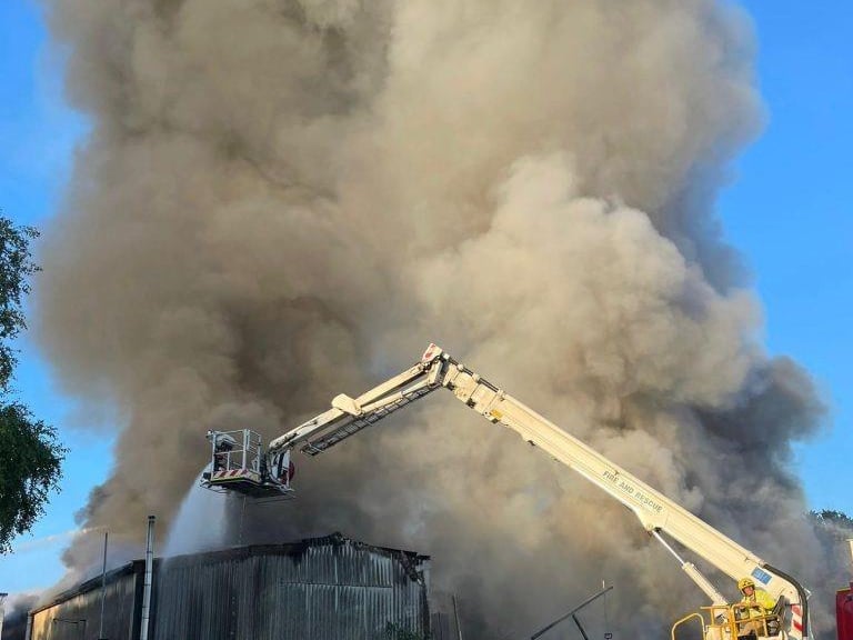 More than 80 firefighters were deployed to tackle a ferocious garage fire, which spread to nearby vehicles and buildings. Smoke could be seen filling the sky.