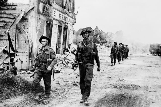 British soldiers cross 08 June 1944 the village of Douet, after the town of Bayeux fell, after Allied forces stormed the Normandy beaches. D-Day, 06 June 1944 is still one of the world's most gut-wrenching and consequential battles, as the Allied landing in Normandy led to the liberation of France which marked the turning point in the Western theater of World War II. (Photo credit should read STF/AFP/Getty Images)