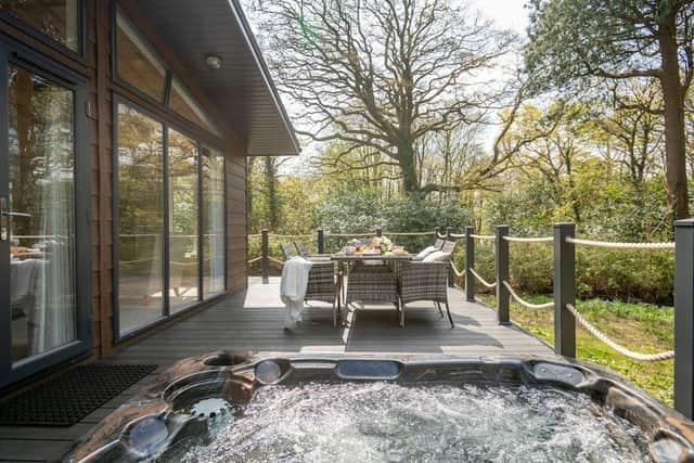 Sliding doors in the Argel Spa lodge lead to a furnished hot tub deck affording sweeping woodland views.