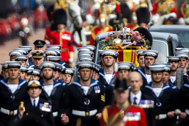 Royal Navy Sailors walk ahead and behind the coffin of Queen Elizabeth II, as it travels on the State Gun Carriage of the Royal Navy from Westminster Abbey to Wellington Arch in London on September 19, 2022, after the State Funeral Service Photo by Odd Andersen/AFP via Getty Images