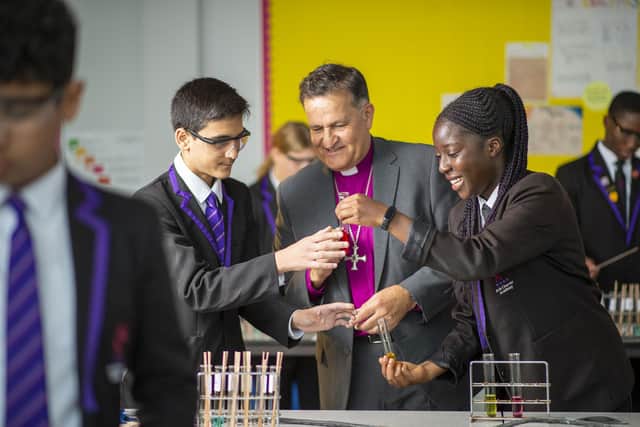 Bishop Jonathan at Charter Academy with pupils Areen Saeed, left, and Christina Barnard