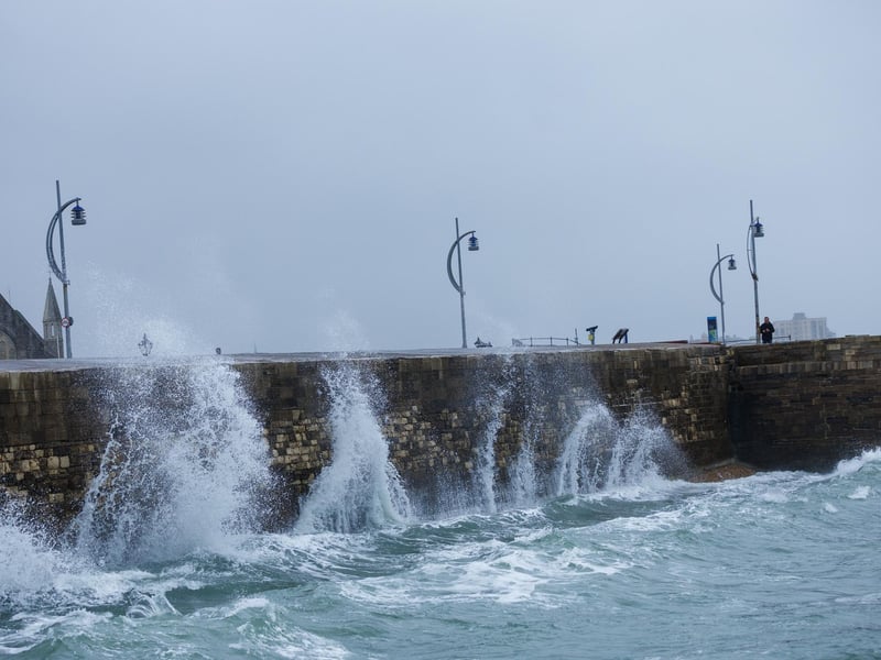 A moody sea crashed waves high onto footpaths as passer-by's did their best to get out the way