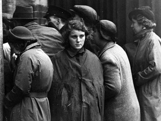 15th October 1939: Anxious relatives read a list of survivors from the HMS 'Royal Oak' posted up at a South Coast Port. The Admiralty states that battleship was sunk by a U-boat.  (Photo by E. Phillips/Fox Photos/Getty Images)