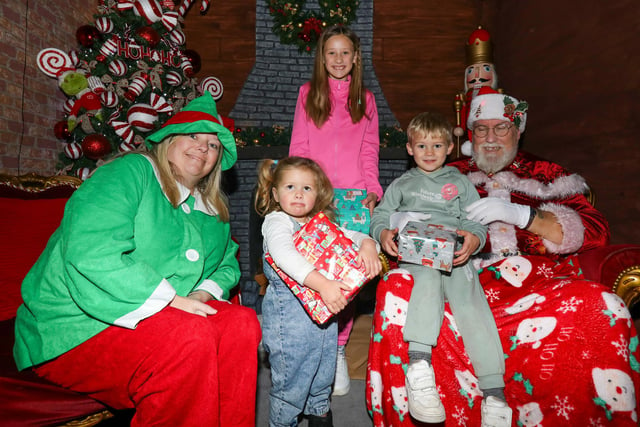 Children, from left, Laya, 2, Hattie, 9, and Arnie, 4 meet Father Christmas and one of his elves. Leigh Park Christmas grotto at Greywell Shopping Centre, Leigh Park, Havant Picture: Chris Moorhouse (jpns 251123-40)
