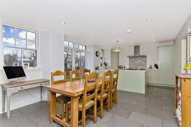 The dining kitchen boasts double-glazed sash windows and French doors, which open out onto the private garden. The space also features composite stone worktops