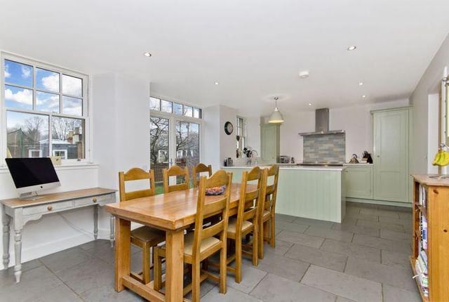 The dining kitchen boasts double-glazed sash windows and French doors, which open out onto the private garden. The space also features composite stone worktops