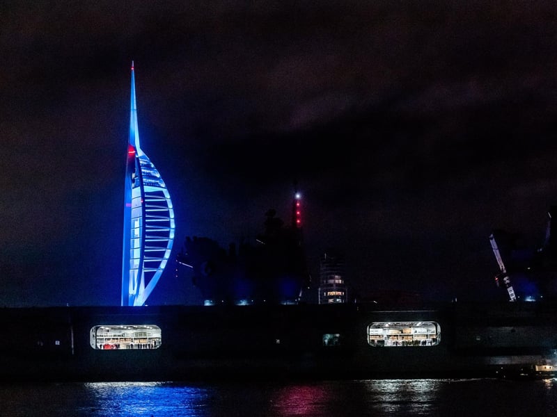 HMS Queen Elizabeth sailing past the Spinnaker Tower illuminated in colours for Elin Martin.