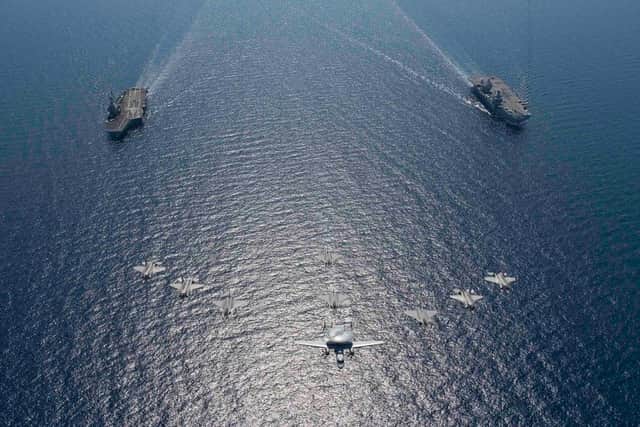 HMS Queen Eliizabeth, pictured right, next to the French aircraft carrier FS Charles De Gaulle for the first time as jets from both ships fly overhead. Photo: Royal Navy