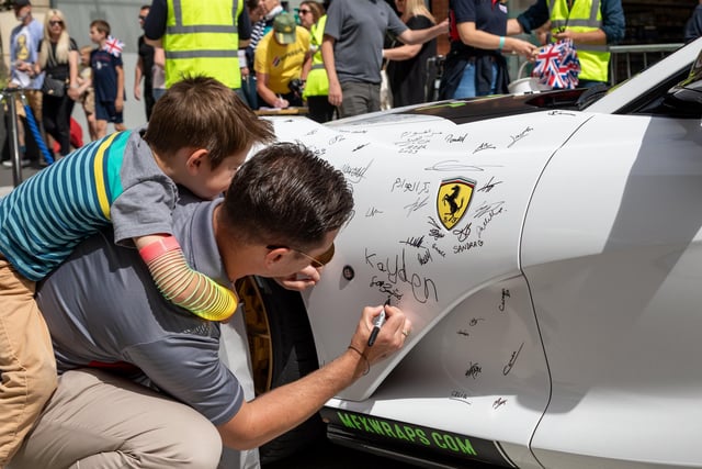 Kayden Breen (4) with dad Seth Breen (33) from Virginia USA added their signatures to the Ferrari. 
Picture: Mike Cooter (290723)