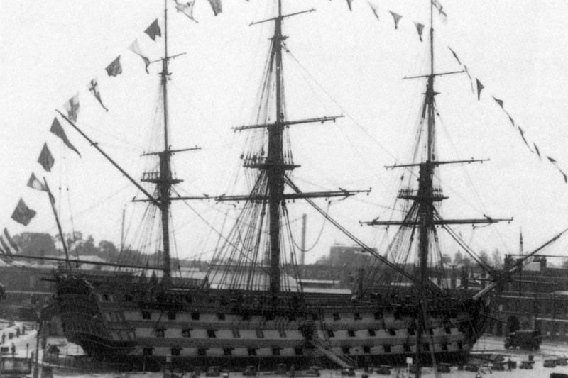 Trafalgar veteran HMS Victory between the wars dressed overall for Empire Day, undated.