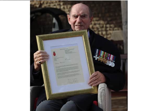 Captain Duncan Knight holds a framed letter from the First Sea Lord. Photo: Royal Navy
