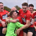 Jon Webb is mobbed after Fareham's penalty shoot-out win against Jersey Bulls. Picture by Paul Proctor