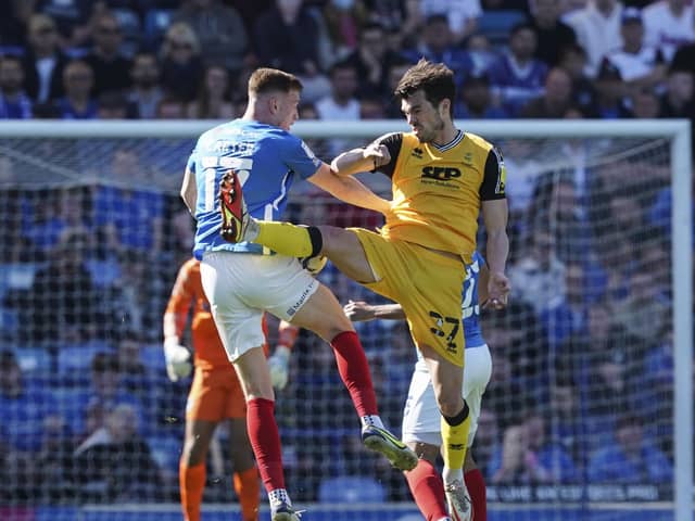 Hayden Carter and John Marquis battle for the ball on the striker's Fratton return.