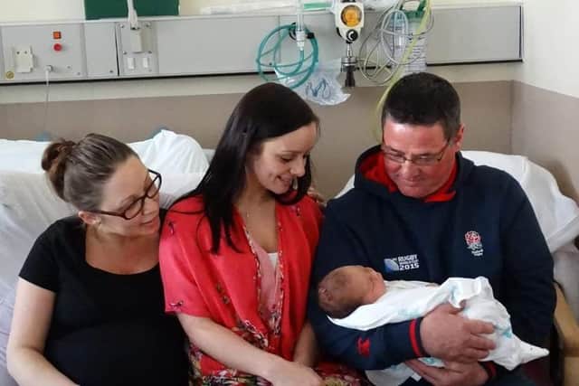 Andrew Oliver, right, holds his grandchild Ruby. Pictured with daughters Amy, middle, and Lucy, left.