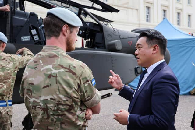 Havant MP Alan Mak talks to a pilot in front of the AH 64E helicopter